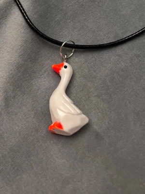 Halsband Gås Smycke  - Vem vill inte ha ett halsband med en fin gås! Berlocken är ca 2,5 cm hög och trädd på en svart tråd, justerbar 45-50 cm. 