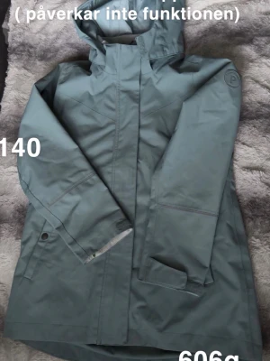 Turkos skaljacka från Polarn o pyret - Turkos skaljacka från Polarn o pyret med huva och dragkedja framtill. Jackan har tryckknappar vid ärmsluten, praktiska fickor och diskret logga på ärmen. Tillverkad i vattenavvisande material som skyddar mot regn och vind. 🌸 Fläckar. En liten söm har släppt lite ( påverkar ej funktionen. Skrap på vid slutet av ärmarna. Storlek 140