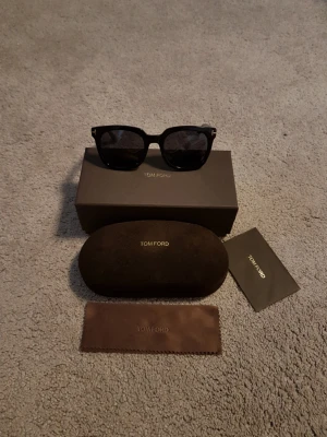 Tom Ford Svarta Solglasögon - Tom Ford Solglasögon, den perfekta accessoaren inför sommaren. Svarta bågar med mörka linser, följer med box fodral osv, allt på bilderna ingår