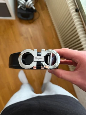 Silver Ferragamo bälte  - Snygg Svart Ferragamo bälte gjort av läder med glansig silver logga. 110cm. Skicka prisförslag!🔥