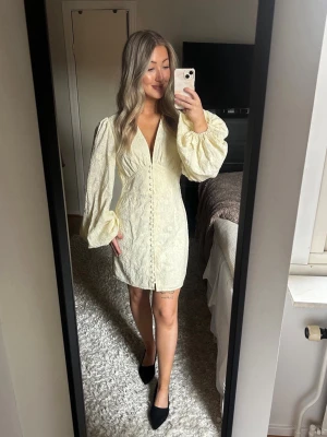 Adoore klänning Florence ljusgul - Superfin ljusgulklänning från Adoore, modellen Florence. Använd en gång,  OBS! En knapp längst ner har lossnat (se sista bilden). Ordinarie pris 1495kr, säljs för 1000kr. Storlek 38. Skriv om det önskas fler bilder.