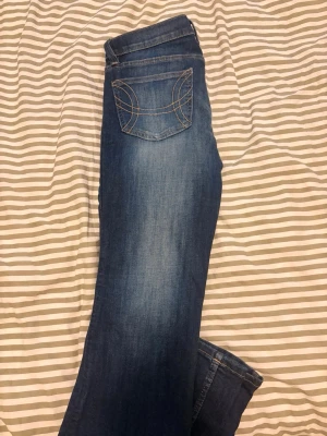 Blå bootcut jeans med kontrastsömmar - Snygga blå bootcut low jeans med ljus tvätt och kontrastsömmar på bakfickan. Klassisk femficksmodell och normal midja. Jeansen har en avslappnad passform och är perfekta för en casual look. Materialet är mjukt denim i bomull. Endast testade på! 