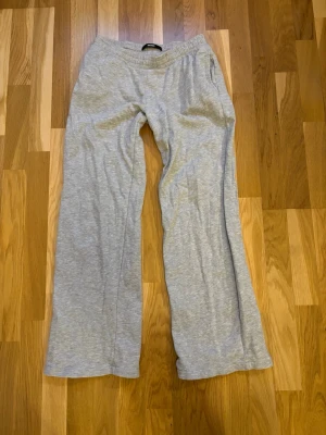 Grå mjukisbyxor från BikBok - Säljer ett par nice ljusgrå mjukisbyxor från BikBok med snörning i midjan. Säljer för att de e lite för korta på mig dem krympte i tvätten😔 ja är 167 för referens💗 inte upptrampade eller skadade alls längst ner heller💞💞