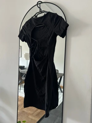 Svart tajt mini klänning - Svart tajt mini klänning med öppen rygg och en snygg knytning i ryggen, väldigt bra skick och skönt material.💕