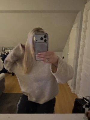 Beige oversized stickad tröja - Mysig beige stickad tröja med oversized passform och breda ärmar. Tröjan har rund halsringning och ribbstickade muddar vid ärmslut och nederkant. Perfekt för lager på lager och en avslappnad look.