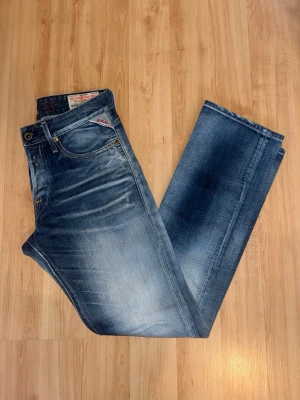 Repaly jeans  - Feta jeans från Replay med både ljusa och mörka jeansfärger. Jeansen har en rak fassform. Obs besluten är något slitna - se närbild. Midja 42cm, längd 109cm. Jag har ingen bild när jag bär jeansen på. För bättre inblick i passformen rekommenderar jag att googla på modellnamnet. För storleksguide kolla måtten noggrant då jeansen alltid kan vara uppsydda heller krympta och jag ej tar emot returer :) 1,86