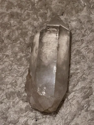 Klar kvarts kristallspets - Säljer en klar kvarts kristall med naturlig spetsform. Kristallen är genomskinlig med vissa vita inslag och har flera slipade sidor. Perfekt som dekoration, samlarobjekt eller för dig som gillar kristaller och mineraler.