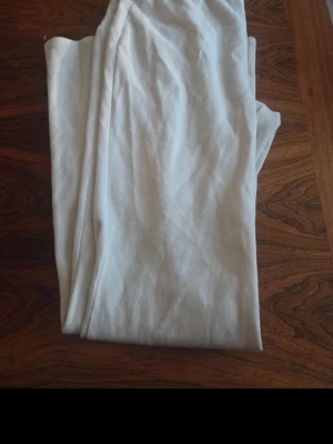 Vita ribbade leggings - Säljer ett par vita leggings med ribbad struktur. De är mjuka och stretchiga, perfekta för en avslappnad och trendig look. Passar till oversized tröjor eller hoodies. Inga synliga detaljer eller loggor.