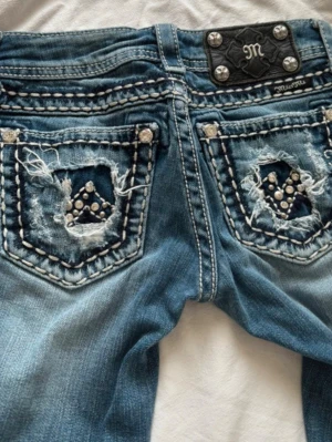 Miss Me blå bootcut jeans med nitar - Säljer ett par blå Miss Me jeans med bootcut-modell. Säljer för att de är för små 💕storlek 23 som motsvarar xxs ☺️midja: 34cm + stretch, längd: 83cm