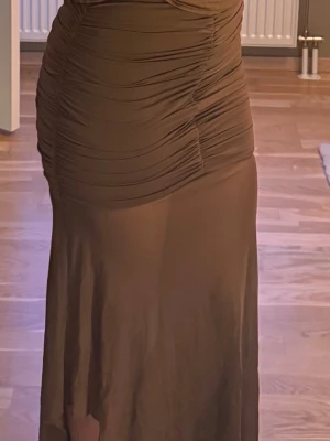 Brun kjol med transparent tyg  - Superfin långkjol med skurning nedtill och rynkad upptill. Aldrig använd, köpt i Mexiko i en lokal butik. Perfekt till sommaren! Säljer då jag inte kunde prova den i butiken och den är något för kort för mig (170cm) upptill. 