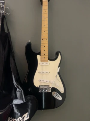 Svart elgitarr från Behringer - Säljer en svart elgitarr från Behringer med vit plektrumskydd och ljust trägreppbräda. Gitarren har tre single coil-mikrofoner, volym- och tonkontroller samt en klassisk Stratocaster-form. Perfekt för dig som vill börja spela elgitarr. Med kommer en förstärkare (bild kommer snart) pris kan diskuteras. möts gärna upp i stockholm / eskilstuna!