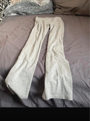Grå utsvängda yoga pants - Snygga grå leggings med utsvängda ben och hög midja. Perfekta för en chill och trendig look. Mjukt och stretchigt material som sitter skönt hela dagen.