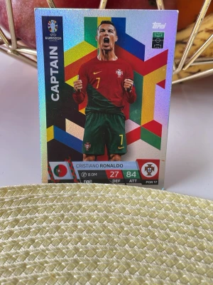Match Attax UEFA Euro 2024 Portugal-kort - Samlarbild från Topps Match Attax UEFA Euro 2024 med Portugal-tema. Kortet har färgstark design, holografisk yta och visar en portugisisk spelare i röd tröja och gröna shorts. Perfekt för dig som gillar fotboll och samlarkort.