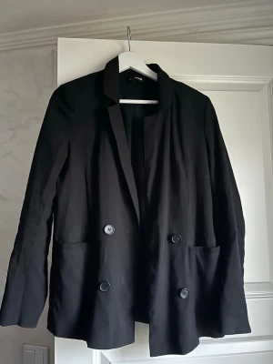 Svart Kavaj - Säljer en svart oversize kavaj i storlek S. Vet dock ej vart ifrån den kommer med tanke på att de ej står ett konkret märke på lappen. Har aldrig använt.