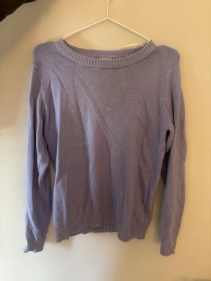 Ljuslila stickad tröja från VILA - Superfin ljuslila stickad tröja från VILA med rund halsringning och ribbade muddar vid ärmslut och nederkant. Perfekt att slänga på sig när det är lite kyligt ute. Enkel och stilren design som är lätt att matcha.