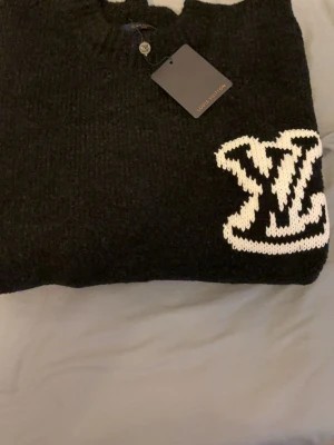 Svart märkes tröja  - Svart stickad designer tröja. Vit logo, jätte skön och och stilig. Helt ny och oanvänd. 