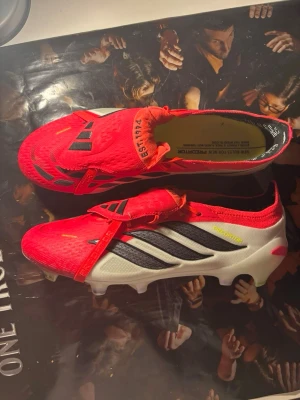 Adidas Predator Elite fotbollsskor - Säljer ett par Adidas Predator Elite fotbollsskor i röd, vit och svart färg. Kan gå ned i pris vid snabb affär. Helt nya aldrig använda