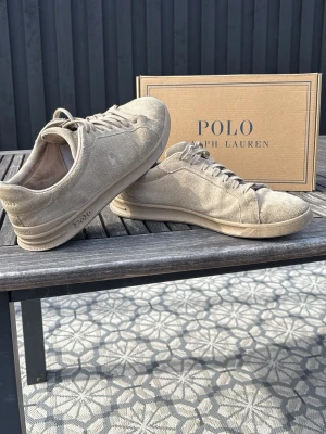 Polo Ralph Lauren Skor - Tja tänkte sälja dessa välanvända polo skorna! Dem är beige i färgen och är gjorda i mocka 😄i positivt är att dem är hela inuti hälen. Dem är i storlek 44 EU. Enda negativa är de lilla hålet ni ser i sista bilden. Hör av er vid eventuella frågor, priset ej satt i sten så kom med bud👍🏼