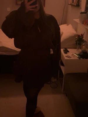 Vinröd omlottklänning med volang - Vinröd kort omlottklänning med långa, vida ärmar och markerad midja. Klänningen har volangdetaljer nertill och är tillverkad i ett lätt, glansigt material som ger en lyxig känsla. Perfekt för dig som vill sticka ut med en elegant och trendig look.