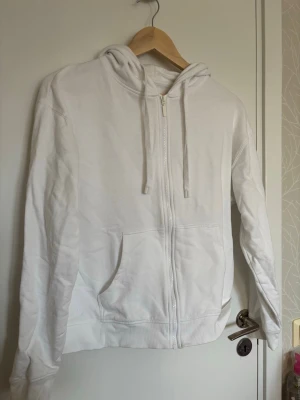 Vit zip-hoodie från Cubus - En vit zip-up hoodie med dragkedja framtill, huva med dragsko och två stora fickor.