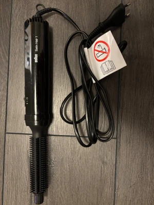 Svart varmluftsborste från Braun - En svart varmluftsborste från Braun Satin Hair 1 med sladd och EU-kontakt. Borsten har plastpiggar och ett smalt handtag med på/av-knapp. Perfekt för att styla och forma håret med värme. Modellnummer 3530, 200W.