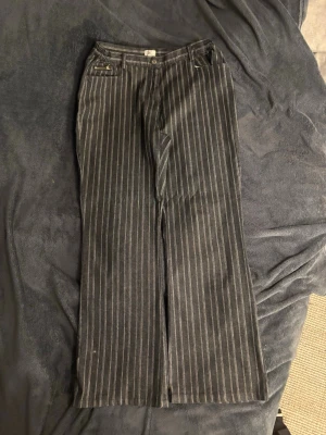 SVARTA CLASSY JEANS 👡 NÄSTAN KOSTYMBYXOR !! - Snygga svarta kostymbyxor med vita kritstrecksränder och raka, vida ben. Klassisk passform med hällor för skärp och fickor fram. Perfekta för en stilren och trendig look. Storlek står ej men passar mig som har L/ 42 ! 💕 De passar även på M. Aldrig använda! Midjemått (rakt över): 39 cm men stretchiga. Grenen och upp: 30 cm. Innerbenslängd: 80 cm 💙