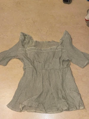 Grå offshoulder blus med volang - Gulaktig off-shoulder blus 💛 Fin sommartopp. Den är inte så stretchig vid armarna :( men annars generellt så sitter den bra. Finns inte så mycket att säga om den här blusen då den är väldigt basic. Har använts ett fåtal gånger men har inte några slitningar eller delar som är sönder. Det finns tyvärr ingen lapp där det står vart den kommer ifrån :(