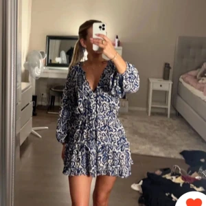 Blåvit mönstrad kortklänning Zara - Säljer en snygg blåvit kortklänning från Zara med unikt mönster och v-ringning! Klänningen har långa, puffiga ärmar. Säljer då den är lite liten på mig. 