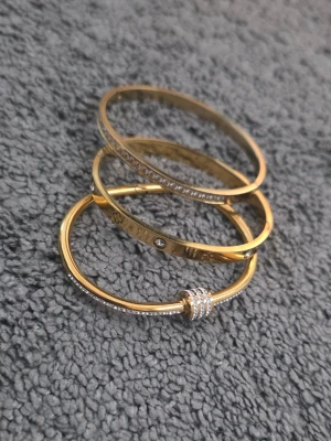 Guldiga armband i stål med stenar - Säljer 3 fina armband i guldfärg med stenar ✨ Väldigt fint skick och knappt använda. Säljes som set för 200 kr eller styckvis 100 kr/st 💕