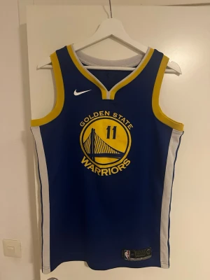 Golden State Warriors basketlinne - Snyggt blått basketlinne från Nike med Golden State Warriors-logga och nummer 11 på framsidan. Klay Thompson 2019 Linne