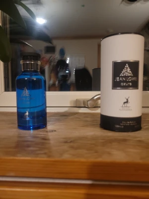Jean Lowe Azure parfym 100ml - Fräsch parfym från Maison Alhambra, Jean Lowe Azure. Flaskan är blå med svart lock och har en modern, stilren design. Kommer i en vit och svart cylinderförpackning. Innehåller 100 ml Eau de Parfum.