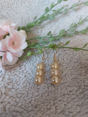 Örhängen med vaxpärlor  - Örhängen med vaxpärlor  Krokarna är av guldfärgad metall  Djur finns I hemmet Rökfritt 