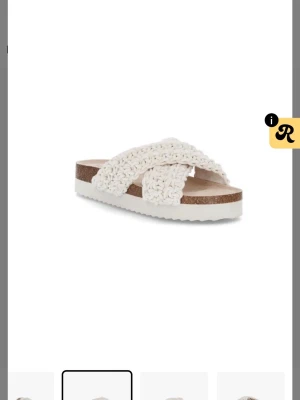 Vita flätade slip-in sandaler - Snygga slip-in sandaler med korsade, breda flätade band i vitt. Sulan är i kork-look med vit räfflad undersida för extra grepp. Perfekta för en chill och trendig sommarstil. Materialet på banden ser ut att vara textil med en stickad känsla. Nypris ca 700kr Skeiv för egna bilder 