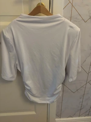 Vit basic t-shirt i bomull - En enkel vit t-shirt med normal passform och korta ärmar. Tillverkad i mjuk bomull, perfekt för en clean och stilren look. Passar till det mesta och är ett måste i garderoben.
