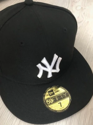 Svart New Era 59FIFTY NY keps - Säljer en svart New Era 59FIFTY keps. Den var för liten för mig så den har aldrig varit använd den har bara varit på en hylla. Köpte för 500 säljer för 399 du kan gärna buda.