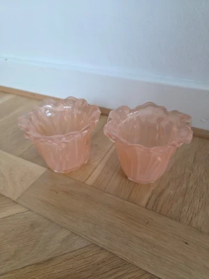 2 st Värmeljuslyktor i aprikost - 2 st Värmeljuslyktor i färg aprikost och är tillverkade i glas. Vågig kant 8 cm höga och ca 10 cm i diameter 