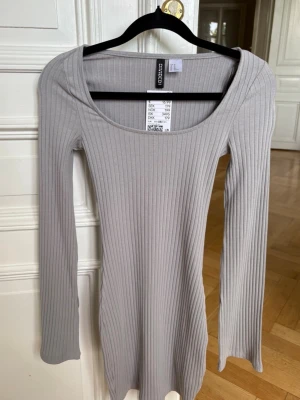 Ljusgrå ribbad klänning  - Supersnygg ljusgrå ribbad klänning från H&M Divided med lång ärm och rundad urringning. Klänningen är figurnära och har en enkel, stilren design som passar perfekt till olika looks. Tillverkad i mjukt och stretchigt material för skön passform. Nypris - 179🤩🙏🏼