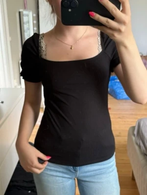 Svart topp  - Snygg svart topp med puffärmar och fyrkantig urringning. Toppen är ribbad och har en tight passform, perfekt till jeans eller kjol🤩