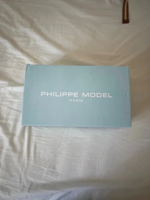 Philippe Model blå mocka sneakers - Nästan helt nya eftersom jag har haft på mig de 3 gånger men de är för små så jag ska sälja Snygga sneakers från Philippe Model i mörkblå mocka med vita detaljer och vita skosnören. Klassisk låg modell med vit sula och diskret logga på sidan. Perfekta för dig som gillar stilrena och trendiga skor. 39-40 priset kan diskuteras 