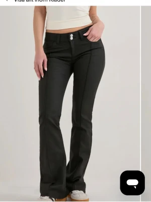 Svarta bootcut skinbyxor - Snygga svarta lågmidjade skinbyxor med dubbla knappar i midjan. 