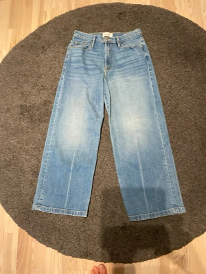 Ljusblå raka jeans med hög midja från Frans, model Ali Wide Coop st 28 - Säljer ett par ljusblå jeans med raka ben och hög midja. Jeansen har klassisk femficksdesign och är tillverkade i denim. Perfekta för en avslappnad och trendig stil. Midjemått 78 cm och beninnerlängd  66 cm. Grenmått bak 37 cm.
