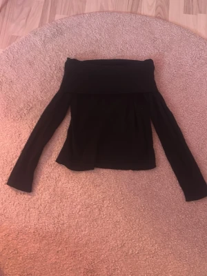 Svart offshoulder topp - Säljer en svart offshoulder topp med långa ärmar. Det är en liten modell så den känns inte som en xl.