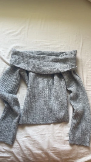 Grå off shoulder stickad tröja - Säljer en ribbstickad grå off shoulder-tröja. Väldigt mysig, inte nopprig.