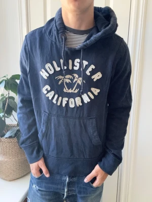 Hollister hoodie  - Hollister hoodie, lite stor på modellen. Ostruken, Inga defekter! Modellen i bilderna är 180 cm 75 kg och bär Storlek M , Kom med frågor! 🌟 (Kan gå ned i pris vid köp av paket 😉) 