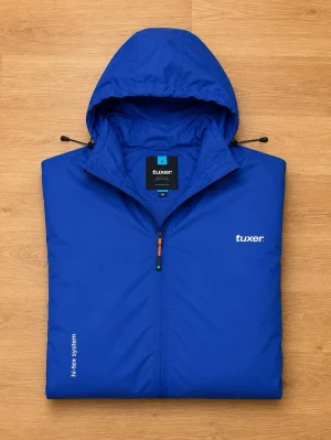 Tuxer Hi-Tex System skaljacka – Blå – Packbar i ficka – Storlek M/S - Säljer en tunn och smidig skaljacka från Tuxer med Hi-Tex System. Jackan är vind- och vattentålig samt har en andningsbar konstruktion, vilket gör den perfekt för promenader, vandring, resor eller vardagsbruk.  En smart detalj är att jackan kan packas ihop i den vänstra fickan, som fungerar som en praktisk packpåse. Lätt att ta med i ryggsäcken eller väskan när den inte används.  Storleken är S, men jag som har på mig storlek M så passar den väldigt bra.  Den är helt oanvänd och har legat i gard