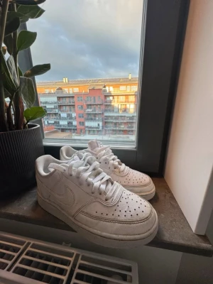 Nike Air force 1, stl 36 - PRISET ÄR PRUTBART Klassiska helvita Nike Air Force 1 sneakers med lågt skaft. Skorna har perforerad tå, kraftig sula och tydliga Nike-loggor på sidan och hälen. Tillverkade i läder med vita skosnören och tidlös design som passar till det mesta.