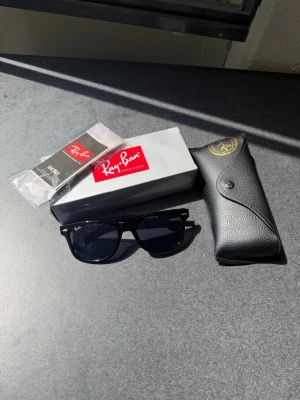 Ray-Ban Wayfarer Solglasögon  - Klassiska svarta Ray-Ban Wayfarer solglasögon med mörka glas. Kommer med originalfodral, putsduk och box. Perfekta för dig som vill ha en tidlös och stilren accessoar till sommaren. 