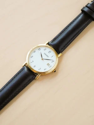 Seiko Quartz Date 7N32-0DE0 - Säljer en Vintage Seiko Date 7N32-0DE0 från 1998. Klockan är i väldigt fint skick utan några repor. 35x41mm guldpläterad boett i rostfritt stål. Original safirglas och juvelbesatt krona.  Nytt batteri och läderarmband.