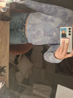 Blå batikmönstrad ribbad tröja - Trendig långärmad tröja i blått och vitt batikmönster. Tröjan är ribbad och har en croppad passform som passar perfekt till höga jeans. Mjuk och stretchig kvalitet som känns skön mot huden. Perfekt för dig som gillar en avslappnad men ändå snygg stil.