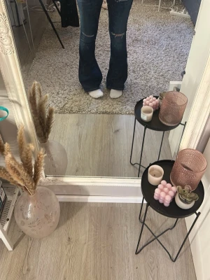 Blå bootcut jeans med slitningar - Säljer ett par blå bootcut jeans med slitningar på knäna och lätt tvättade detaljer. Jeansen har en klassisk ficksmodell och låg midja. Perfekta för dig som gillar en avslappnad men trendig look. Pris kan diskuteras 